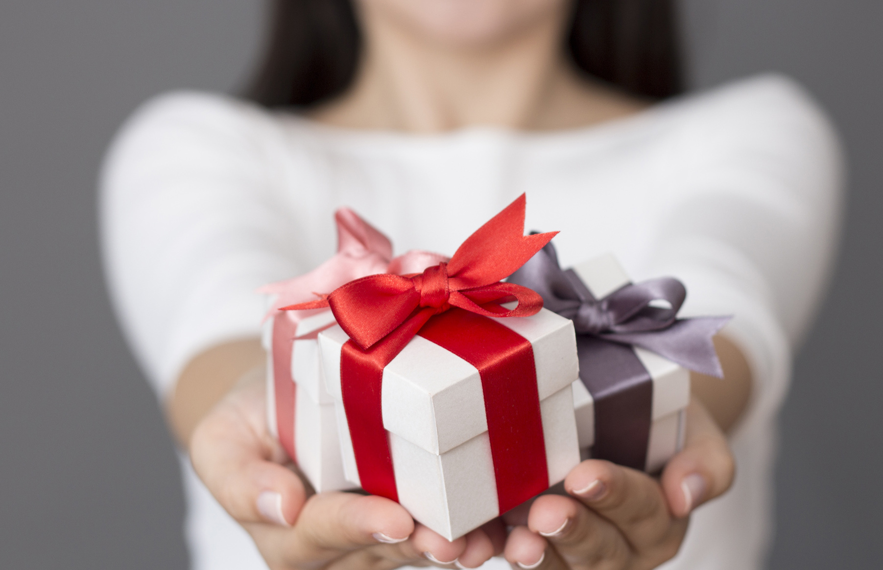 Подарки подскажите. Дарим подарки. Девушка вручает подарок. Подарок в руках. Человек дарит подарок.